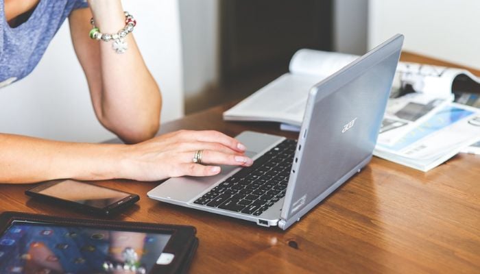 A person using a laptop along with other devices. — Pixabay
