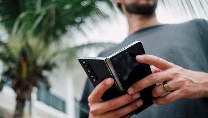 An undated image of a person holding a foldable phone. — Unsplash