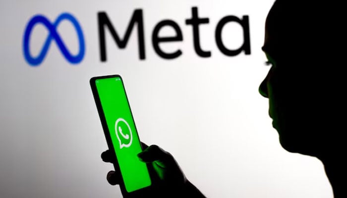 An undated image of a women holding a mobile phone with WhatsApps logo displayed on the screen. — Freepik