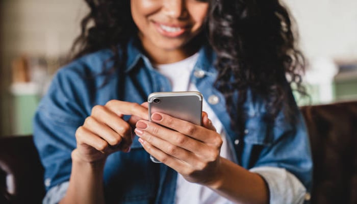 An undated image showing a girl using iPhone. — iStock