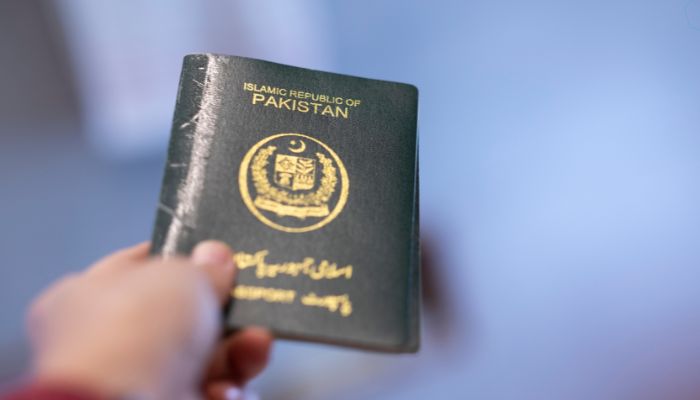 An undated image of person holding a Pakistani passport. — Canva