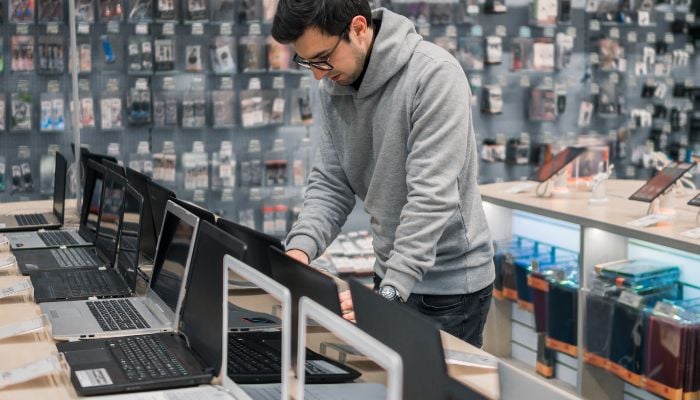 An undated image of a person in a laptop store. — Canva