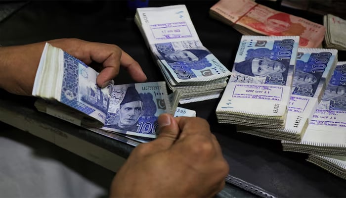 An employee counts Pakistani rupee notes at a bank in Peshawar, Pakistan August 22, 2023. — Reuters