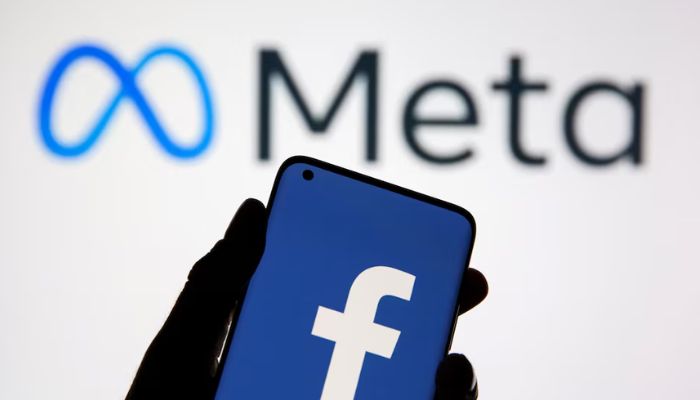 An image of a smartphone with Facebooks logo is seen in front of the displayed Facebooks new rebranded logo, Meta, is in this illustration taken on October 28, 2021. — Reuters
