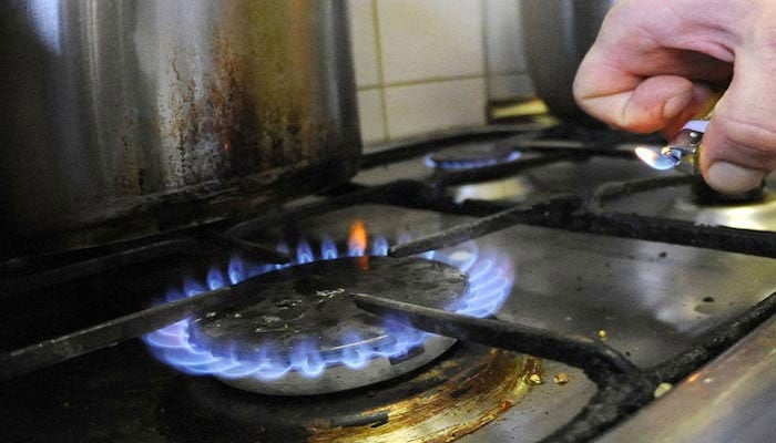 An undated image of a person lighting a stove. — AFP