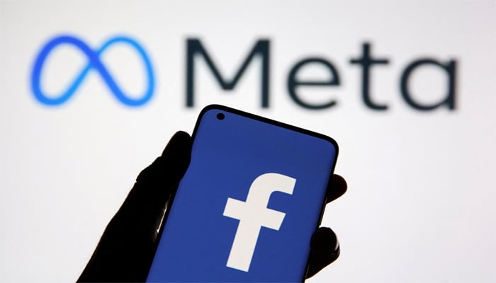 A smartphone with Facebooks logo is seen in front of displayed Facebooks new rebrand logo Meta in this illustration taken October 28, 2021. — Reuters
