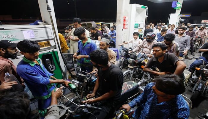 People wait their turn to get fuel at a petrol station, in Karachi, Pakistan June 2, 2022.  — Reuters