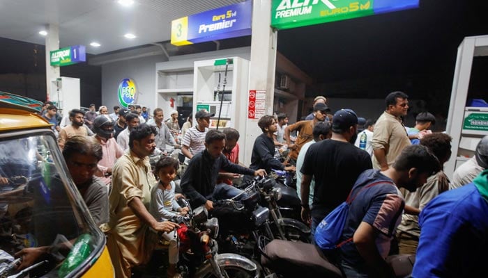 An undated image of motorbikers standing in queues at a petrol station in Karachi. — Reuters